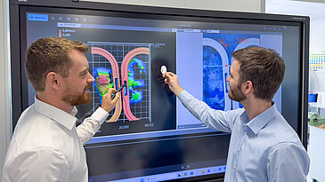 Ultraschallschweiß-Daten werden von zwei Personen auf einem großen Touchscreen analysiert